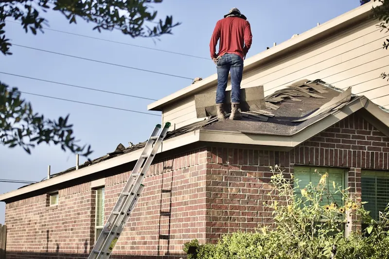 Professional roofer working on a residential roof in Beresford Hall